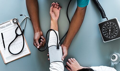 A healthcare professional performing blood pressure monitoring on a patient.